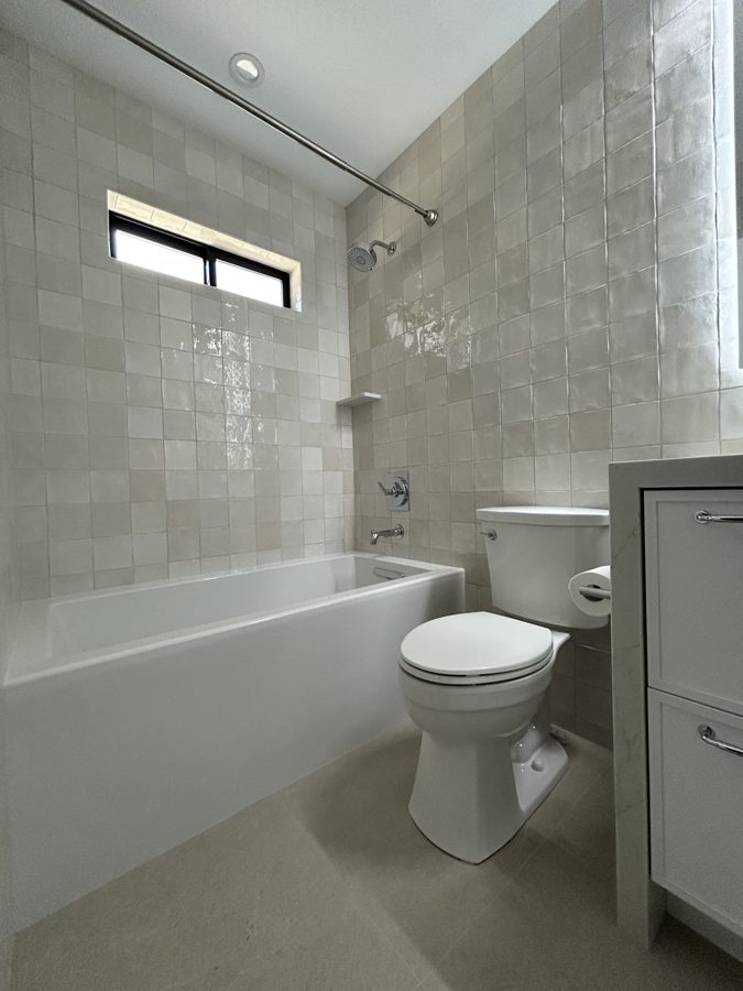 Bathroom with a tiled bathtub surround and vanity